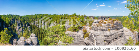 Panoramic view over monumental Bastei sandstone pillars and ancient bridge near Kurort Rathen village in the national park Saxon Switzerland by Dresden and Czechish border, Saxony, Germany. 100926160