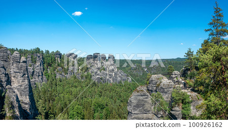 Panoramic view over monumental Bastei sandstone pillars and ancient bridge near Kurort Rathen village in the national park Saxon Switzerland by Dresden and Czechish border, Saxony, Germany. Panoramic view over monumental Bastei sandstone pillars and ancient bridge near Kurort Rathen village in the national park Saxon Switzerland by Dresden and Czechish border, Saxony, Germany. 100926162