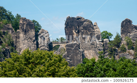 Panoramic view over monumental Bastei sandstone pillars and ancient bridge near Kurort Rathen village in the national park Saxon Switzerland by Dresden and Czechish border, Saxony, Germany. Panoramic view over monumental Bastei sandstone pillars and ancient bridge near Kurort Rathen village in the national park Saxon Switzerland by Dresden and Czechish border, Saxony, Germany. 100926175