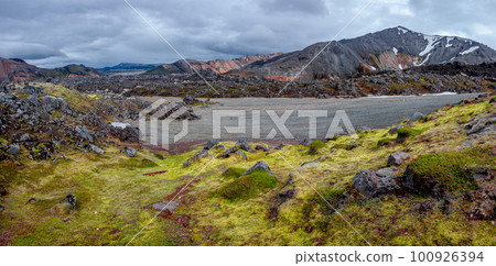 Panoramic Icelandic landscape of colorful rainbow volcanic Landmannalaugar mountains, at Laugavegur hiking trail with dramatic sky, colorful rhyolite volcano soil and lava fields in Iceland. 100926394