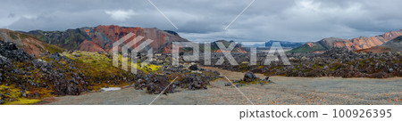 Panoramic Icelandic landscape of colorful rainbow volcanic Landmannalaugar mountains, at Laugavegur hiking trail with dramatic sky, colorful rhyolite volcano soil and lava fields in Iceland. 100926395