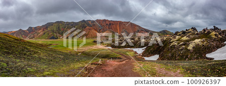 Panoramic Icelandic landscape of colorful rainbow volcanic Landmannalaugar mountains, at Laugavegur hiking trail with dramatic sky, colorful rhyolite volcano soil and lava fields in Iceland. 100926397