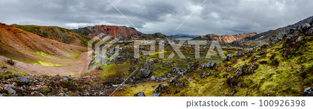 Panoramic Icelandic landscape of colorful rainbow volcanic Landmannalaugar mountains, at Laugavegur hiking trail with dramatic sky, colorful rhyolite volcano soil and lava fields in Iceland. Panoramic Icelandic landscape of colorful rainbow volcanic Landmannalaugar mountains, at Laugavegur hiking trail with dramatic sky, colorful rhyolite volcano soil and lava fields in Iceland. 100926398