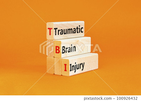 TBI traumatic brain injury symbol. Concept words TBI traumatic brain injury on wooden blocks on a beautiful orange table orange background. Medical and TBI traumatic brain injury concept. Copy space. 100926432
