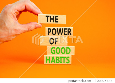 The power of good habits symbol. Concept words The power of good habits on wooden block. Beautiful orange table orange background. Businessman hand. Business power of good habits concept. Copy space. 100926488