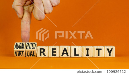 Augmented or virtual reality symbol. Concept words Augmented reality Virtual reality on cubes. Beautiful orange background. Businessman hand. Business augmented or virtual reality concept. Copy space. 100926512