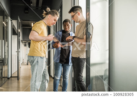 A young developer gives new project tasks to his partners. Business people are discussing a new business project in the office. Coding technologies, site design. Successful diverse Teamwork A young developer gives new project tasks to his partners. Business people are discussing a new business project in the office. Coding technologies, site design. Successful diverse Teamwork 100928305