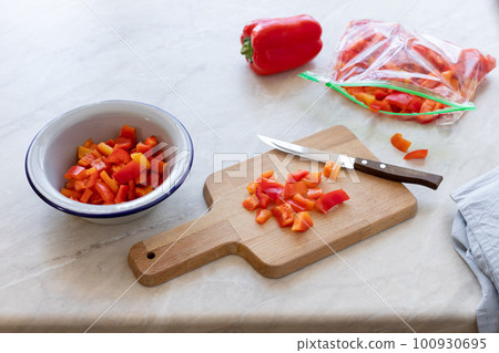 chopped fresh bell peppers on a wooden cutting board. preparation of organic vegetables for freezing. light background. copy space 100930695