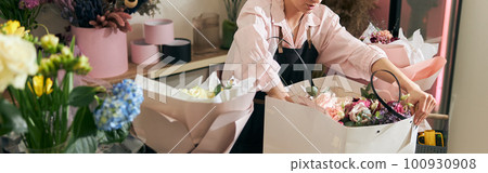 Professional florist young woman is doing bouquets at flower shop Professional florist young woman is doing bouquets at flower shop 100930908