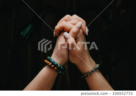 Praying woman meditating, reading mantras, directs thoughts, requests gratitude 100932733