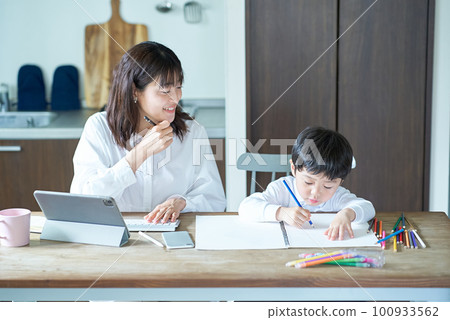 A mother working in her room and a child drawing 100933562