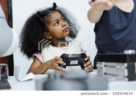 Children girl African American holding  joystick education electronic on table at class room. Children girl African American holding  joystick education electronic on table at class room. 100934634