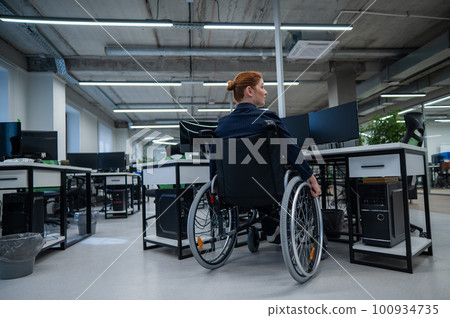 Caucasian woman in wheelchair at work desk. Caucasian woman in wheelchair at work desk. 100934735