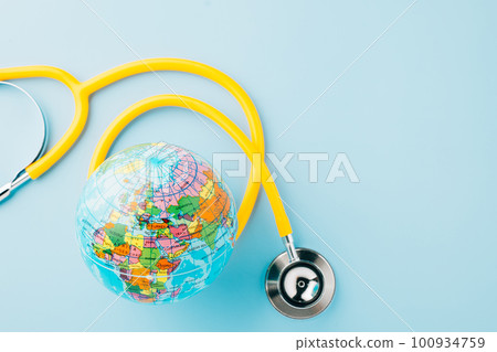 World Health Day. Yellow doctor stethoscope and world globe isolated on blue background, Save world day, Green Earth, Healthcare and medical concept 100934759
