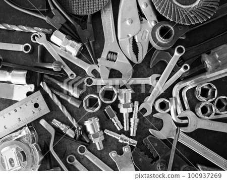 Hand tools consisting of wrenches, pliers, socket wrenches, laid out on old steel plate background. 100937269