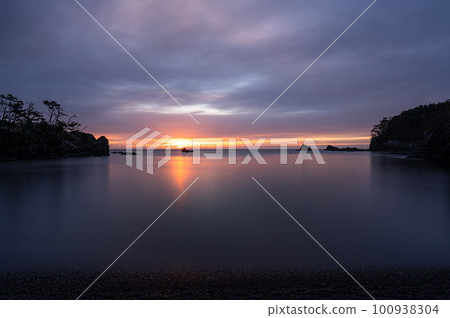 The sun rising from the calm sea Goishi coast 100938304