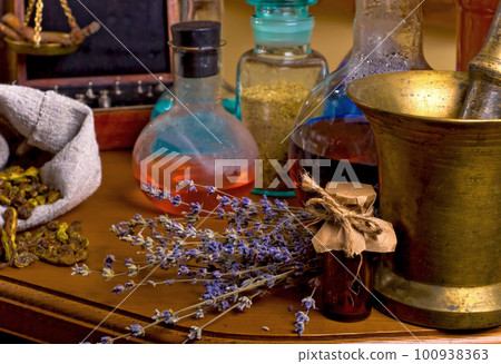 mortar and pestle near potions on wooden table. Dried healing herbs, flowers and candles, ritual purification , copyspace Close up of healing herbs alchemist stuff. Old pharmacy, alternative medicine mortar and pestle near potions on wooden table. Dried healing herbs, flowers and candles, ritual purification , copyspace Close up of healing herbs alchemist stuff. Old pharmacy, alternative medicine 100938363