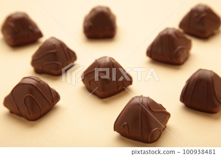 Chocolate candies on a beige background. Top view 100938481