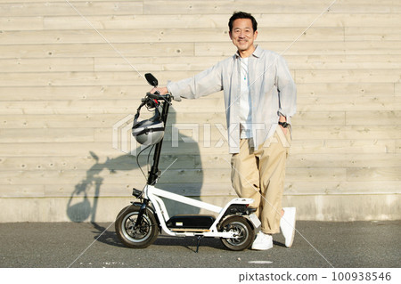 Senior man riding an electric kickboard 100938546