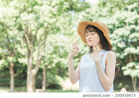 Women spraying sunscreen and insect repellent (problem / neck) 100938673