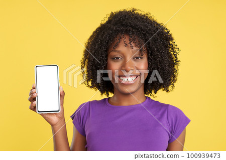 Afro woman smiling at the camera holding a mobile Afro woman smiling at the camera holding a mobile 100939473