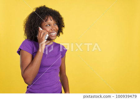 Happy woman with afro hair talking to the mobile 100939479