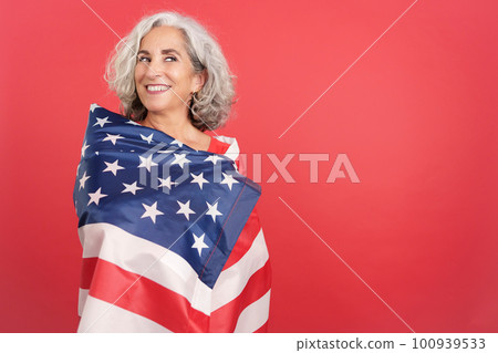 Happy woman wrapping with a north america national flag 100939533