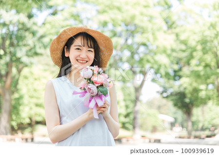 A woman wearing a hat with a bouquet 100939619