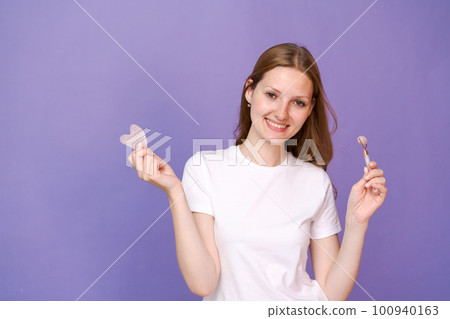 Young lady massaging her face by Gua Sha Quartz Stone Scraper for skin care Young lady massaging her face by Gua Sha Quartz Stone Scraper for skin care 100940163