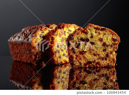 Cake with raisins and candied fruit on a black background. Cake with raisins and candied fruit on a black background. 100943454