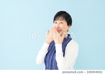 Surprised senior woman hiding her mouth Surprised senior woman hiding her mouth 100944002