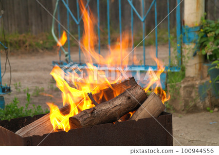 Brightly burning wooden logs with yellow hot flames of fire. Brightly burning wooden logs with yellow hot flames of fire. 100944556