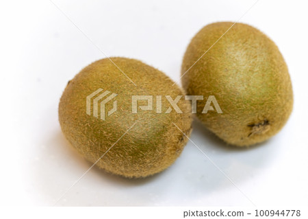 在一張白色桌上的兩個獼猴桃 在一張白色桌上的兩個獼猴桃 100944778