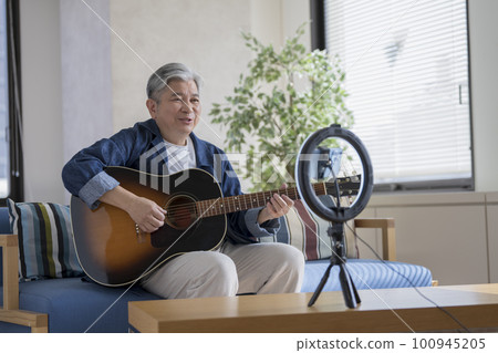 Senior man playing the guitar live streaming image 100945205