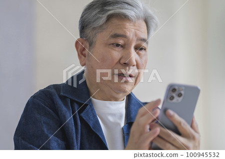 看智能手機屏幕的老人 100945532