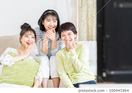 在客廳和朋友一起看電視的年輕女人 在客廳和朋友一起看電視的年輕女人 100945864