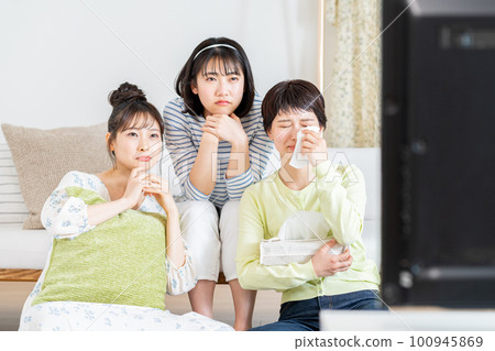 在客廳和朋友一起看電視的年輕女人 在客廳和朋友一起看電視的年輕女人 100945869