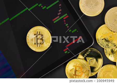 Bitcoin on digital tablet with exchange graph by crypto coins 100945949
