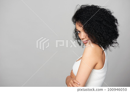 Mixed race girl looking at camera over shoulder Mixed race girl looking at camera over shoulder 100946050