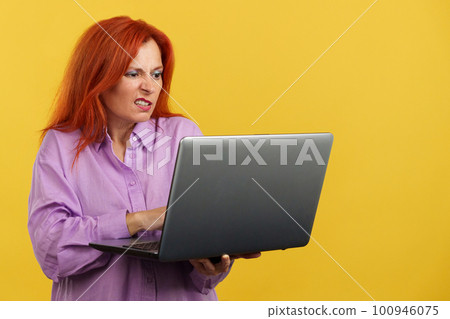 Mature redheaded woman having a problem with a laptop Mature redheaded woman having a problem with a laptop 100946075