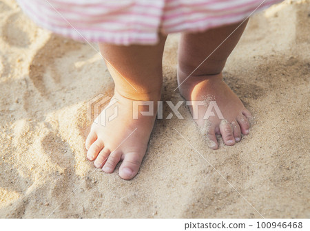 little baby feet of a child who walks along the seashore little baby feet of a child who walks along the seashore 100946468