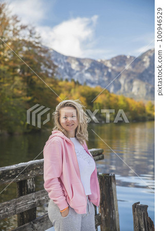 beautiful blonde girl stands near Lake Bohinj in Slovenia 100946529