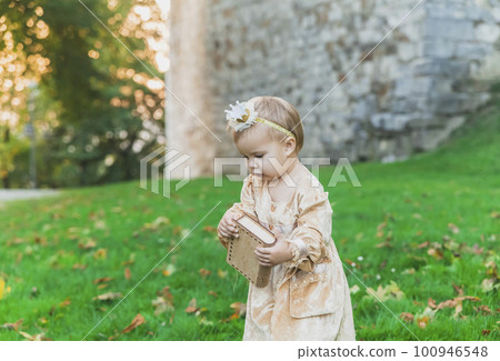 charming baby in princess costume walks near the castle at sunset charming baby in princess costume walks near the castle at sunset 100946548