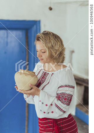 peasant woman in embroidered clothes inhales the aroma of food peasant woman in embroidered clothes inhales the aroma of food 100946568