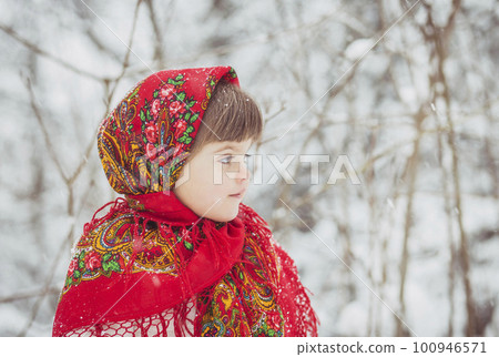 Beautiful little girl in old Russian clothes in a winter forest 100946571