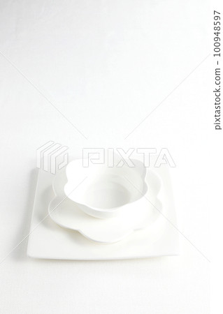 Petal-shaped white porcelain tableware and square plate Taken from an oblique bird's-eye view on a white background Petal-shaped white porcelain tableware and square plate Taken from an oblique bird's-eye view on a white background 100948597