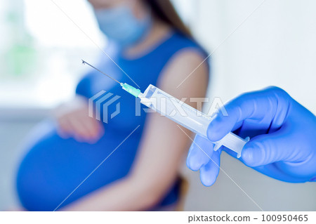 Pregnant Vaccination. Pregnant Woman Getting Vaccinated in Clinic. Doctor Giving Corona Virus Vaccine Injection Patient. Covid-19. Syringe close up 100950465