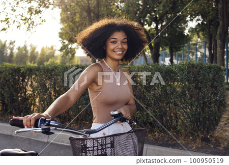 Young and positive afro american girl in casual cloth smiles sweetly and has a fun Young and positive afro american girl in casual cloth smiles sweetly and has a fun 100950519