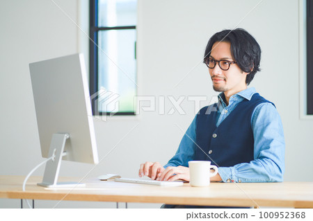 man typing on computer 100952368