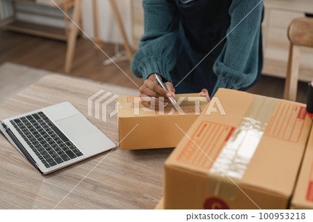 Entrepreneur, small business, SME, freelance woman working from home with lots of boxes on the side. Use smartphones and laptops for commercial monitoring. online marketing packaging box online sale 100953218
